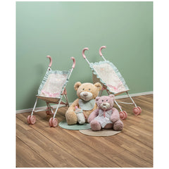 Two teddy bears seated between pink-handled strollers on wooden floor, green wall backdrop.