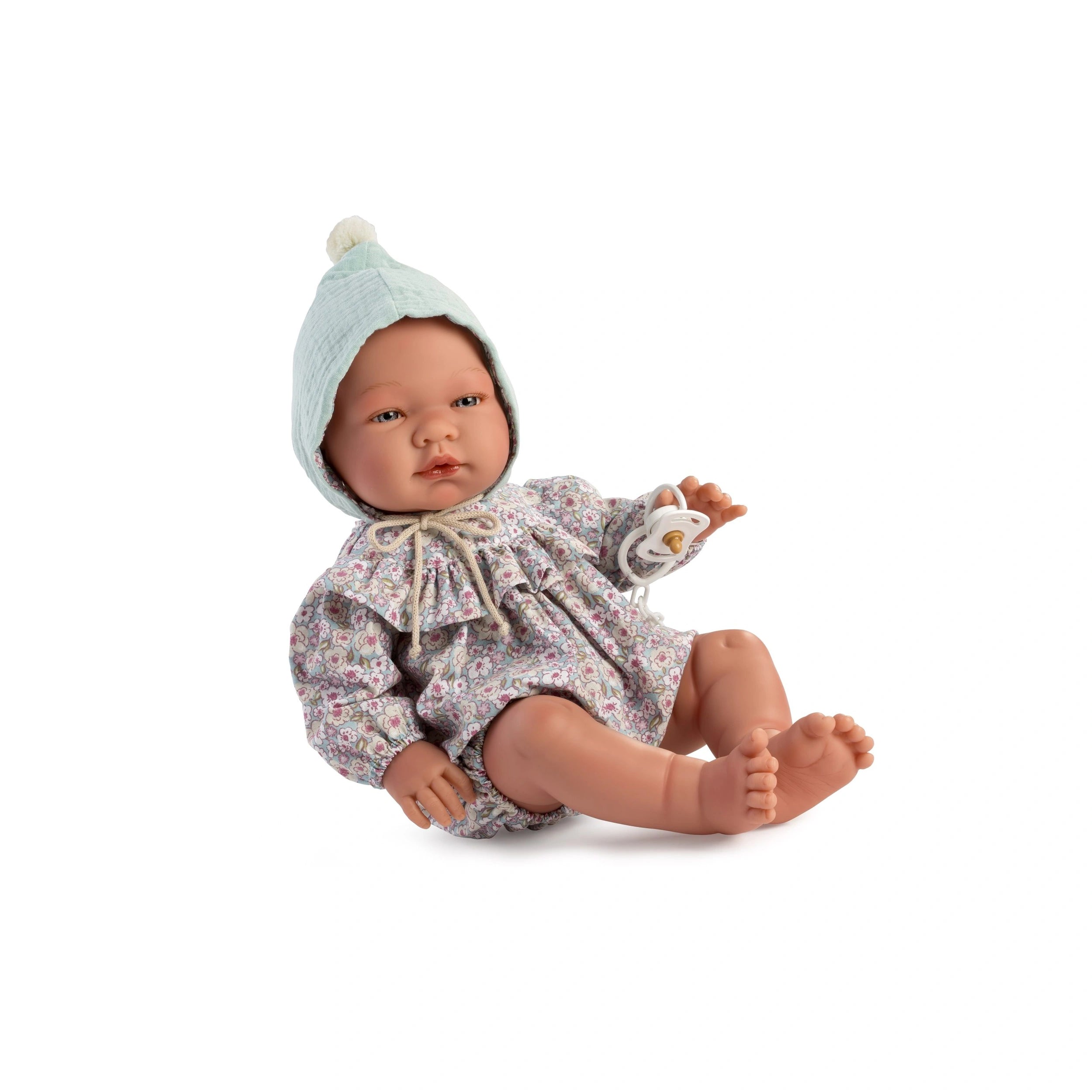 Asi Doll Pablo in floral rompers and mint green hat sitting, holding pacifier.
