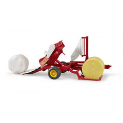 Red Bruder bale wrapper toy with yellow wheels, white and beige round bales on a plain background.