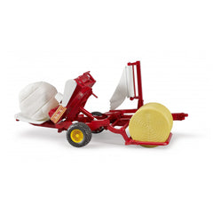 Red Bruder bale wrapper toy with yellow and white round bales on a white background.