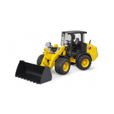 Yellow Bruder Cat Wheel Loader toy with articulated steering, black cabin, and a functional front shovel on a white background.