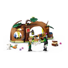LEGO Elphaba's Retreat set featuring a whimsical forest hideout with two figures sharing tea, surrounded by playful bunnies and colorful flowers.
