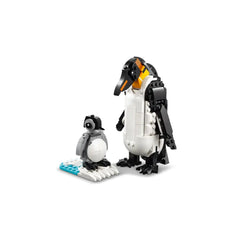 A black and white LEGO penguin couple stands together, featuring a tall adult penguin with a colorful beak and a smaller gray baby penguin beside it, on a blue and white ice base.