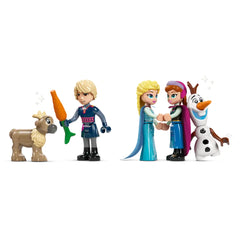 Kristoff holds a carrot next to a smiling reindeer, while Elsa and Anna embrace joyfully. Olaf stands nearby, happy and waving.