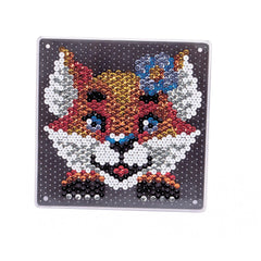 A decorative object featuring a stylized foxs face made of glossy beads in red, blue, yellow, and white, creating a mosaic e