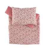 Floral pink and white comforter and pillow set for dolls, showcasing cozy quilted design and pattern.