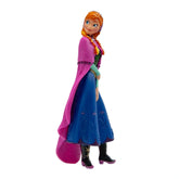 Bullyland Anna toy figure in blue dress, pink cape, black boots, and purple shoes, made of plastic and fabric.