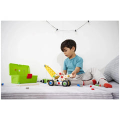 Eichhorn Constructor 4in1 construction set toys are engaging a child on a bed with a toy car and a green toy box nearby.