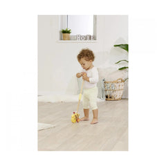 Eichhorn Push Bee toy held by young child in a bright indoor space, showcasing playful interaction with colorful design.