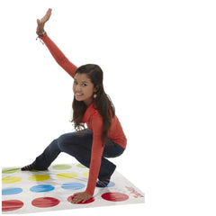 HASBRO Twister Italian Edition board game with a girl in a red top and dark jeans standing on a colorful circle pattern.