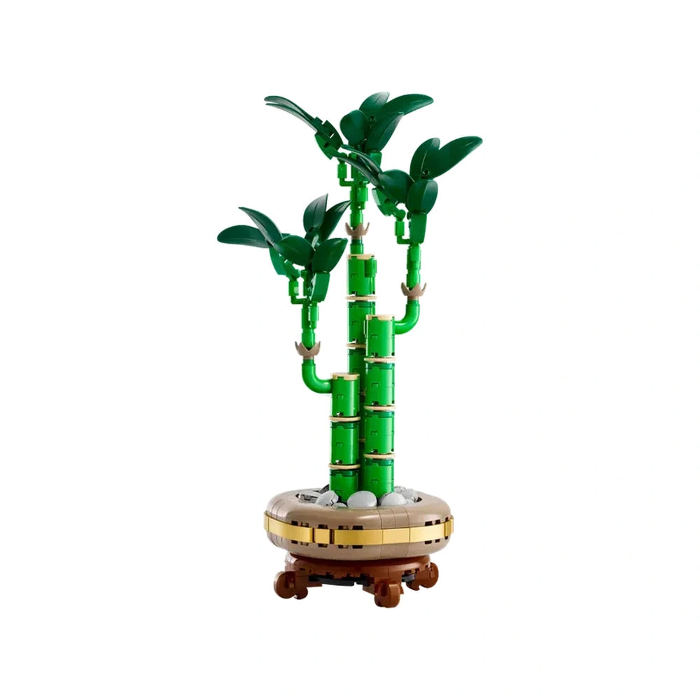 Three green bamboo stems rise gracefully from a round, brown pot adorned with pebbles, capturing the serene essence of nature.