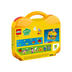Bright yellow LEGO® Classic Creative Suitcase with a handle, featuring images of colorful building creations like houses, trees, and vehicles on the sides.