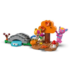Colorful LEGO building set featuring two playful animal characters, a vibrant orange tree, a small bridge, pumpkins, and mushrooms for a whimsical autumn scene.