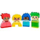 Four colorful LEGO® DUPLO® characters representing diverse emotions: a sad girl with red hair, a cheerful girl in yellow, a happy boy in blue, and a playful boy with green hair, each with distinct facial expressions.