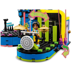 A colorful LEGO construction set featuring a smiling girl playing drums on a vibrant music stage with bright green and blue elements.