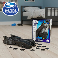 4D Build DC Batman Retro Batmobile 3D Puzzle Model Kit displayed on a wooden floor next to its blue box featuring graphics an