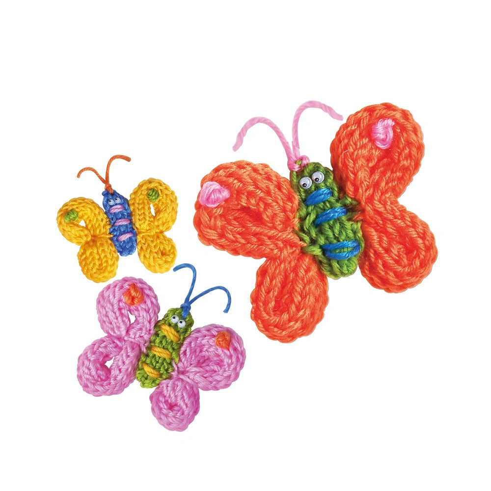 Crocheted butterflies in vibrant colors, featuring green bodies, orange and pink wings, and small blue accents.