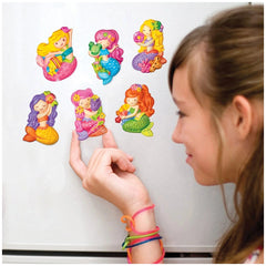 4M Mould & Paint Glitter Crafts features a young girl holding a colorful mermaid sticker on a white surface.