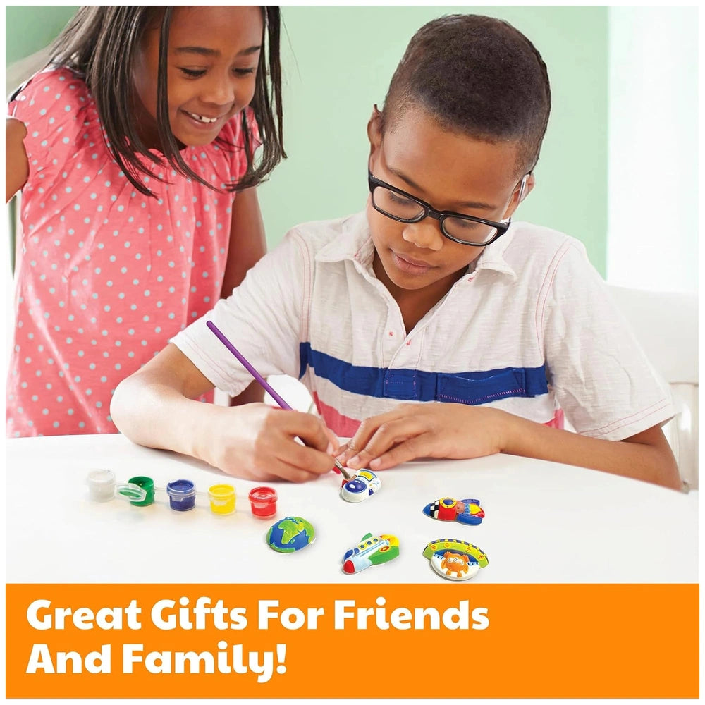 4M Mould & Paint Mermaid kit displayed on a white table with colorful craft items and children engaged in creative activities