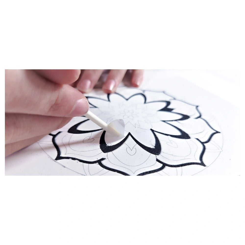 Sand Art Mandala kit featuring a person painting in black on a light surface with a white paintbrush.