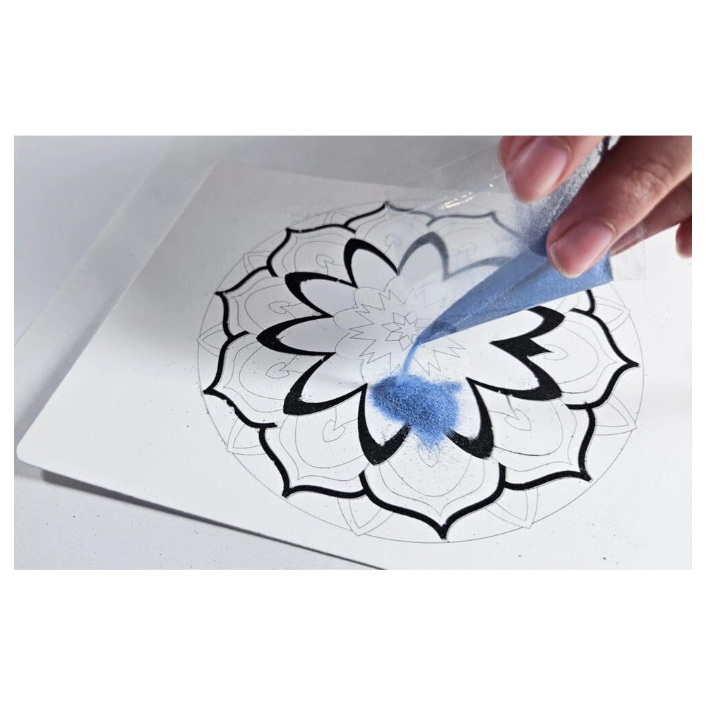 Sand Art Mandala kit featuring a hand applying blue granular powder to a white surface in a circular flower design.