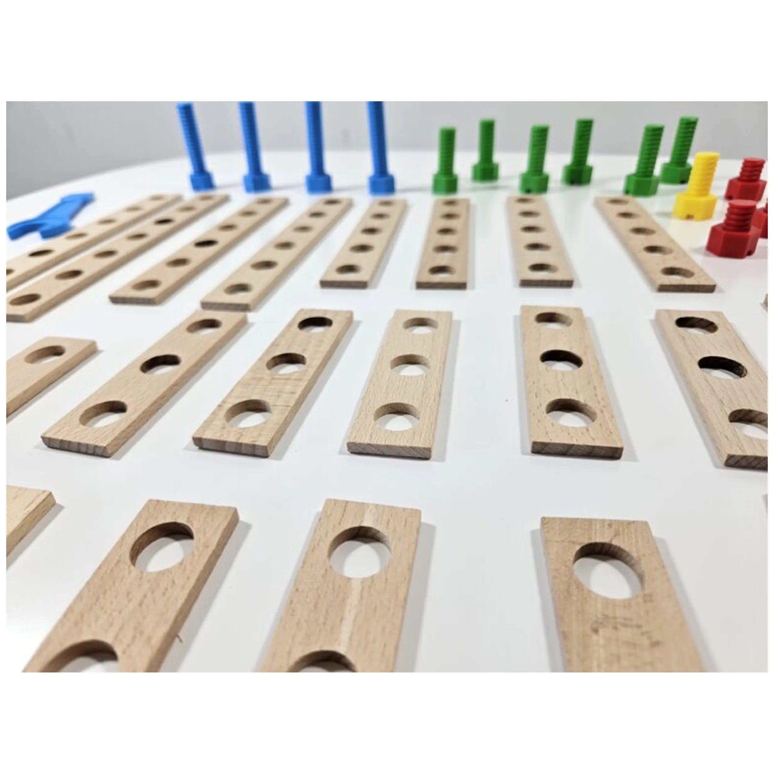 Wooden boards with holes, colorful screws, and connectors from the Alexander Constructor Junior 50-piece set on a white surface.