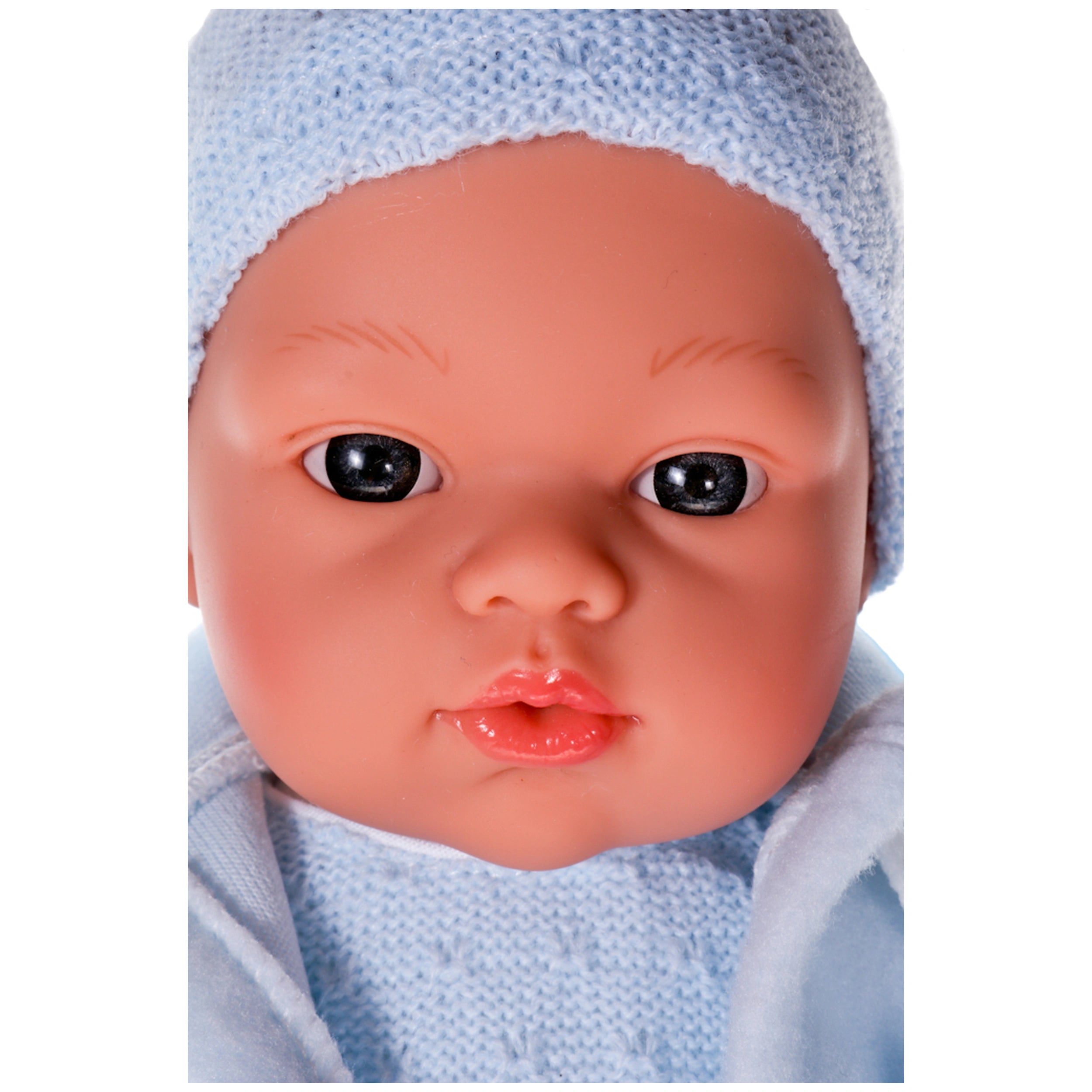 Lifelike Koke doll with blue eyes and knitted blue hat, showcasing realistic features and rosy cheeks.