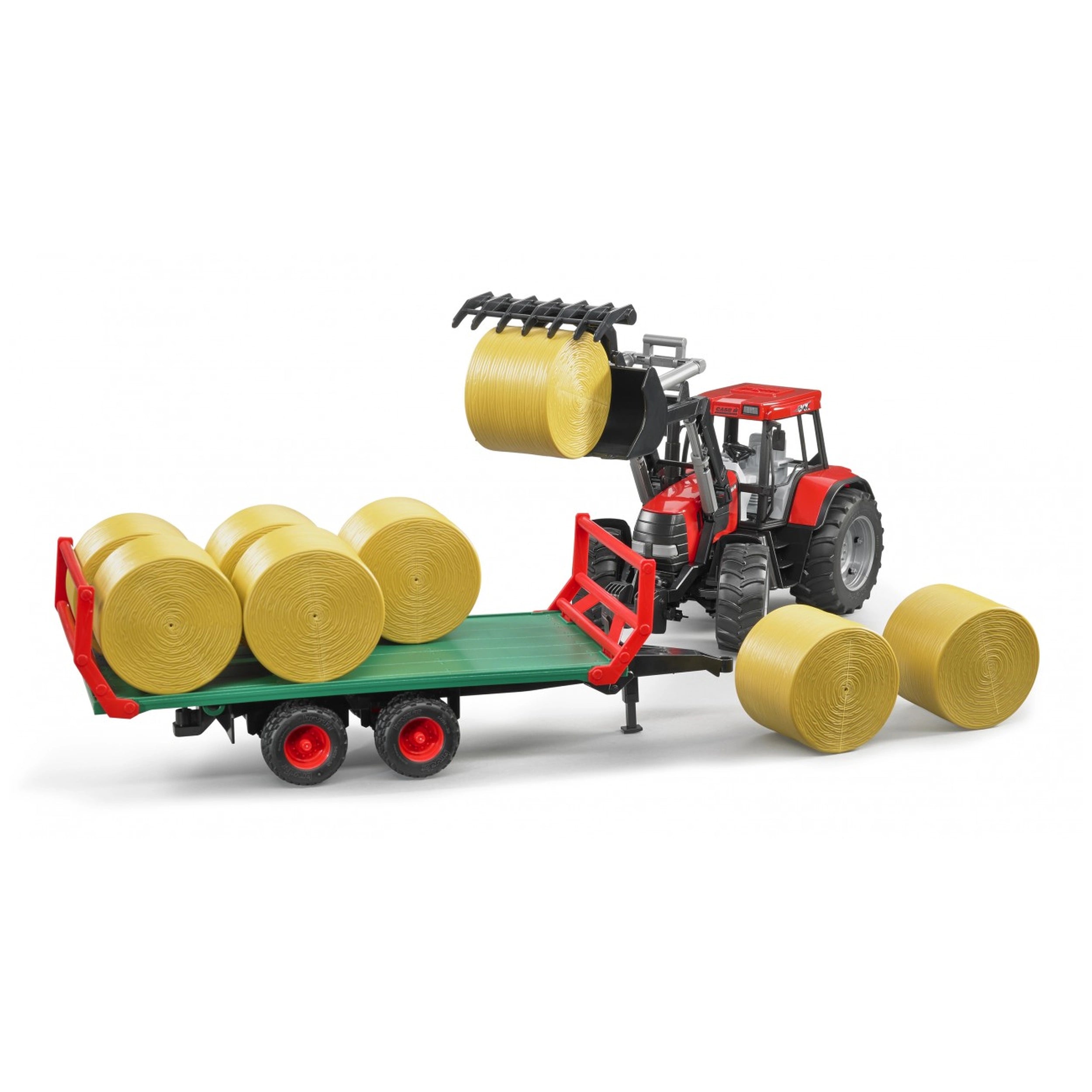 Red toy tractor loading hay bales onto green trailer with red trim, Bruder 1:16 scale play vehicle.