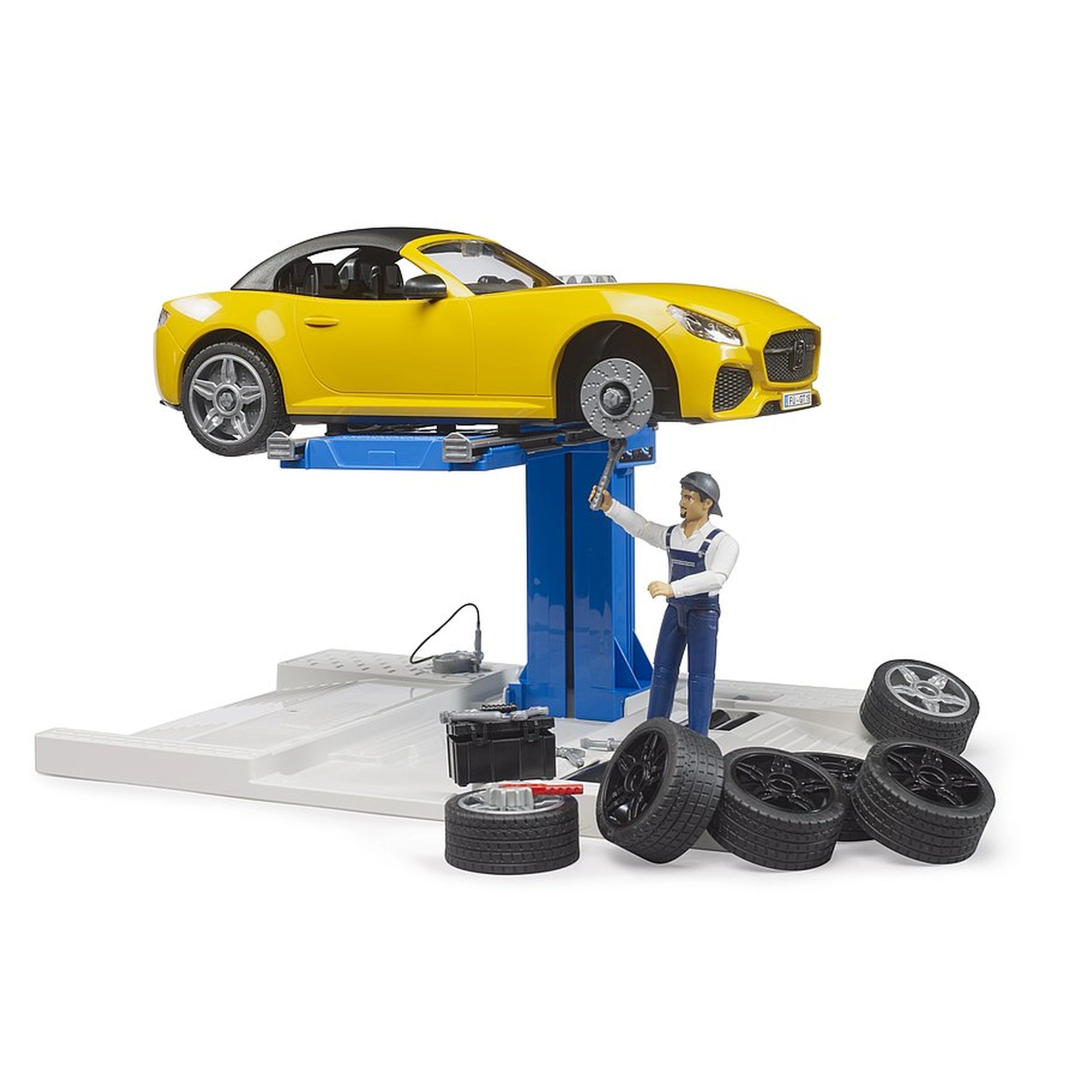 Yellow toy roadster on lift at car service center with mechanic figure and tires around.