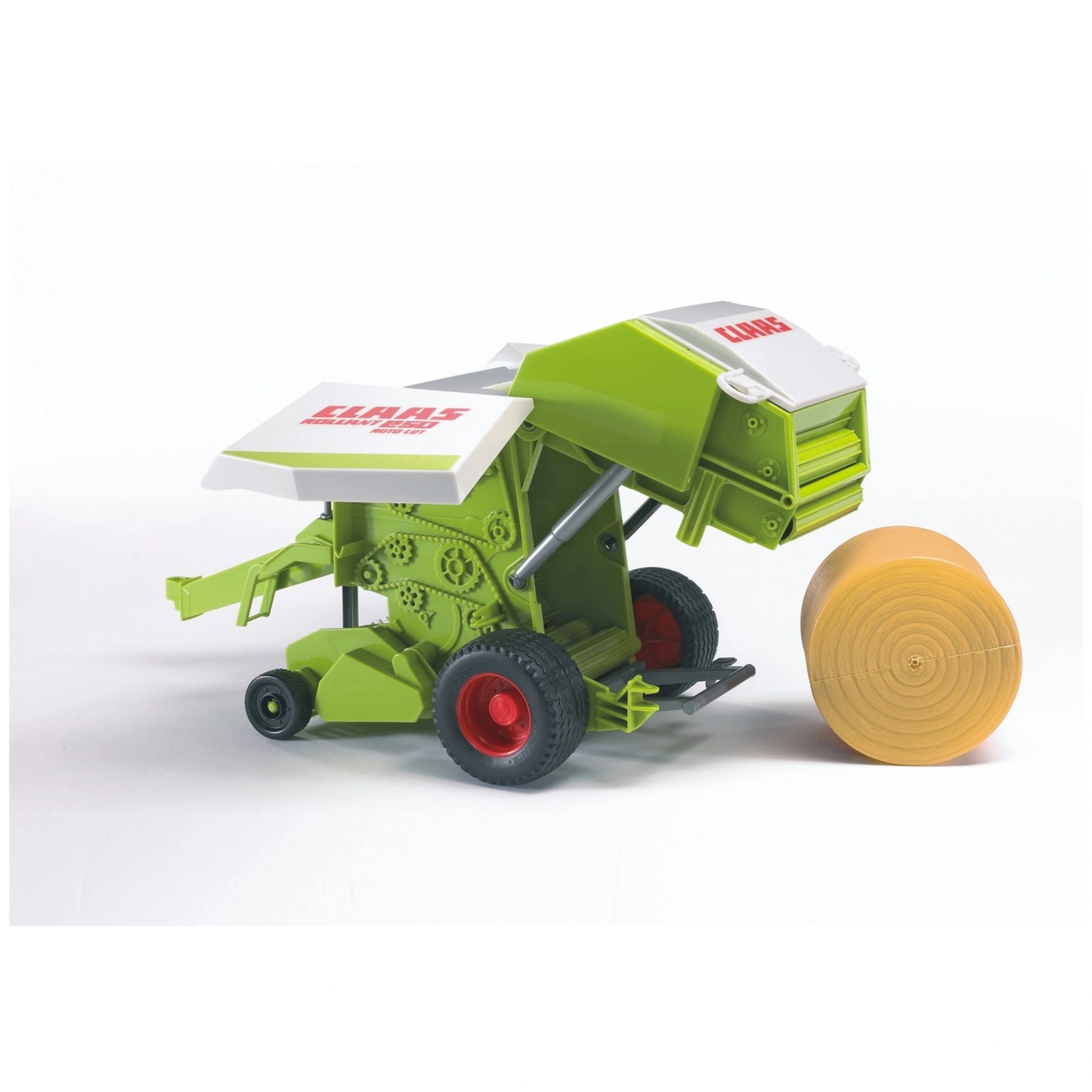 Green and white toy Claas Rollant 250 Straw Baler with red wheels, next to a rolled straw bale.