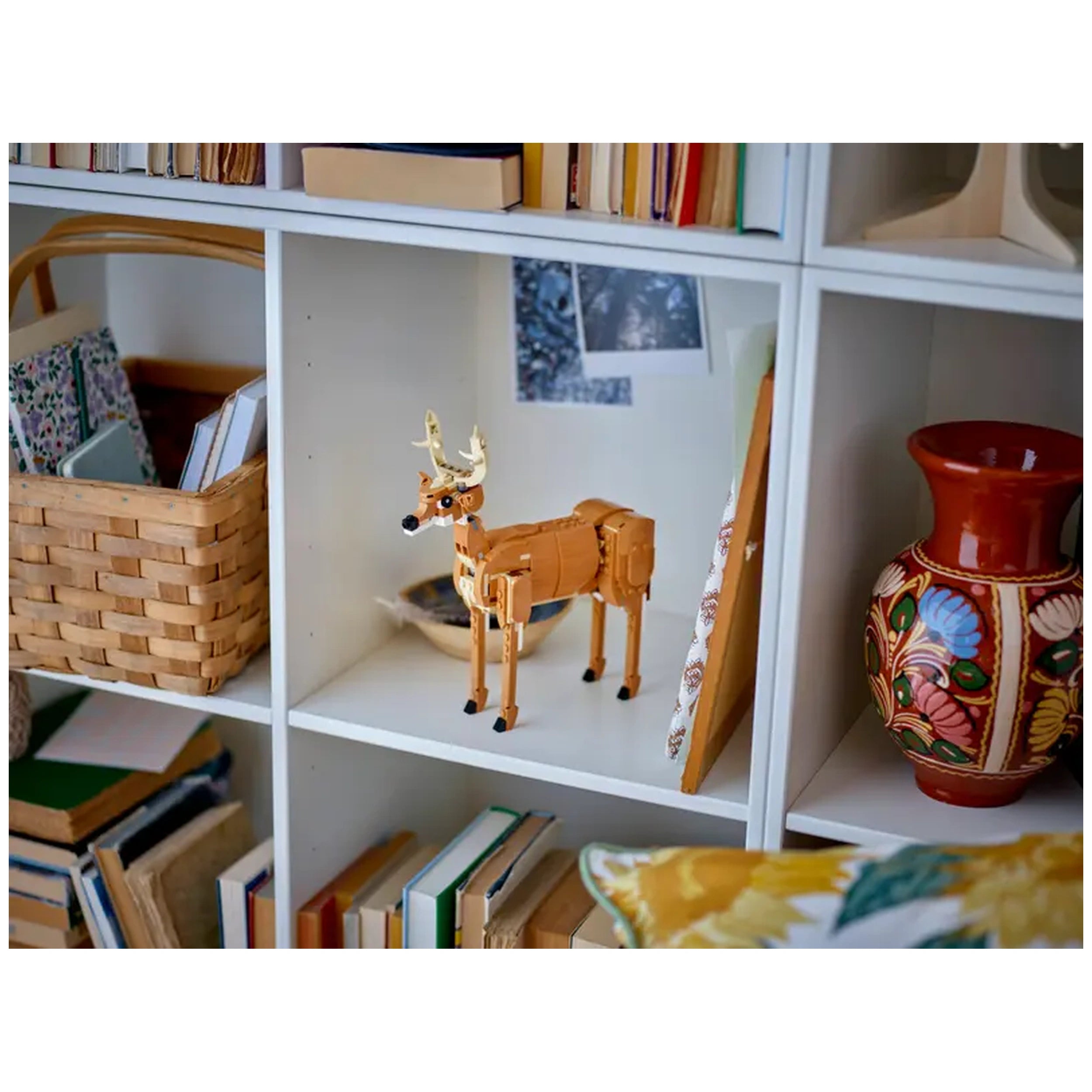 LEGO Creator Beautiful Horse figure displayed on a shelf next to a woven basket and colorful ceramic vase, surrounded by books.