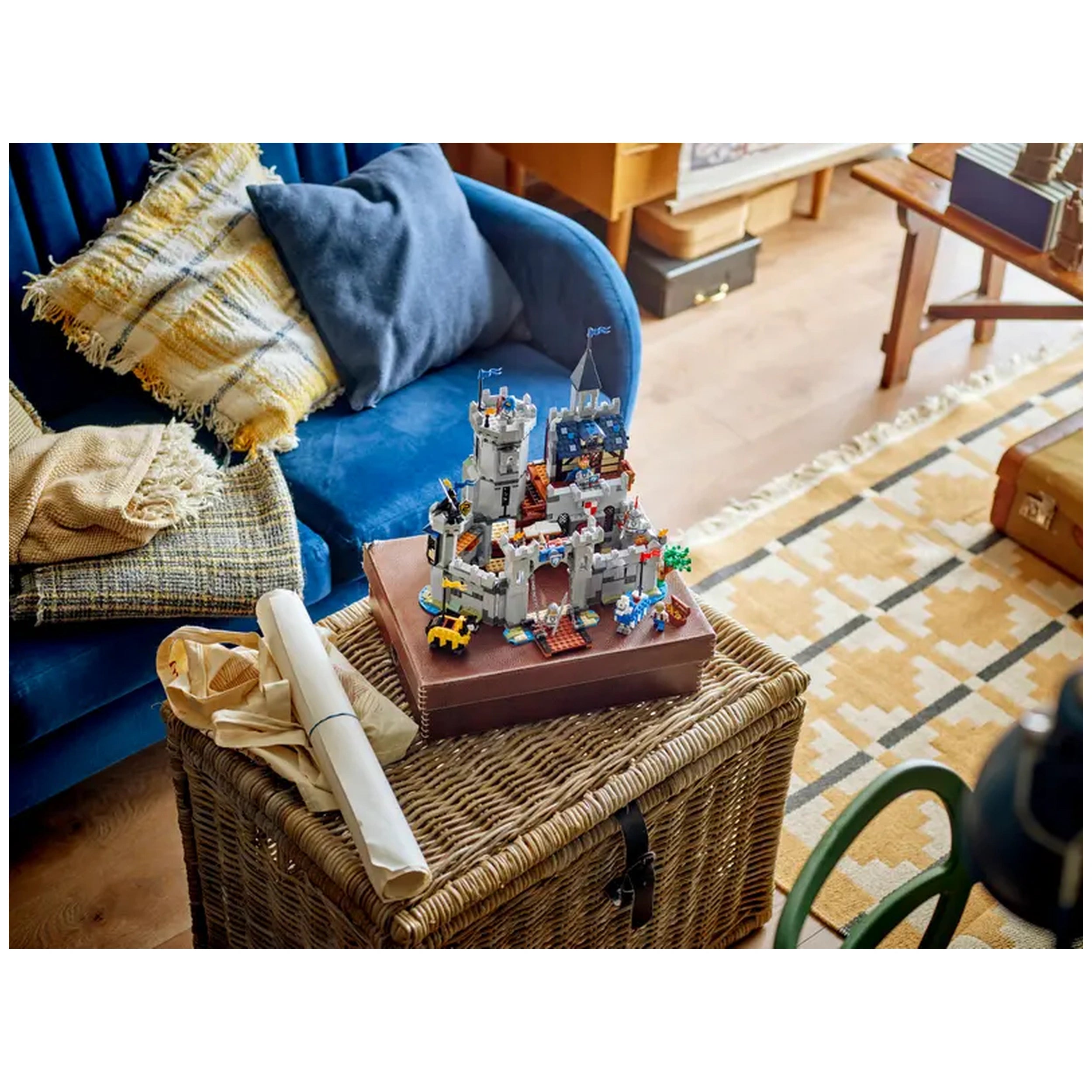 Colorful LEGO® Creator 3in1 Medieval Horse Knight Castle set displayed on a brown box atop a woven storage basket, surrounded by a cozy blue sofa and a patterned rug.