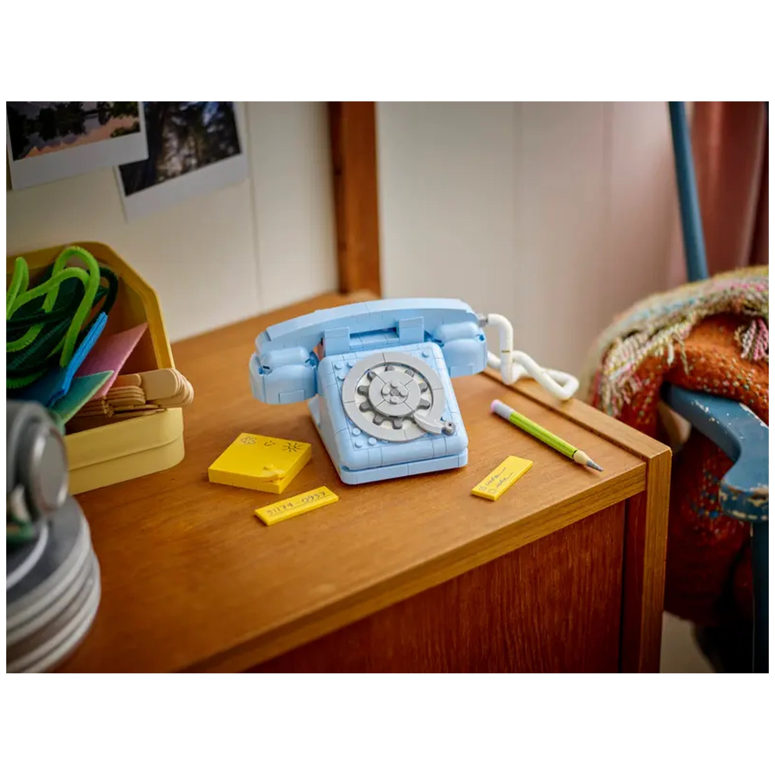 LEGO Creator 3in1 Retro Telephone in soft blue, featuring a rotary dial and cord, on a wooden table surrounded by colorful stationery and notepads.