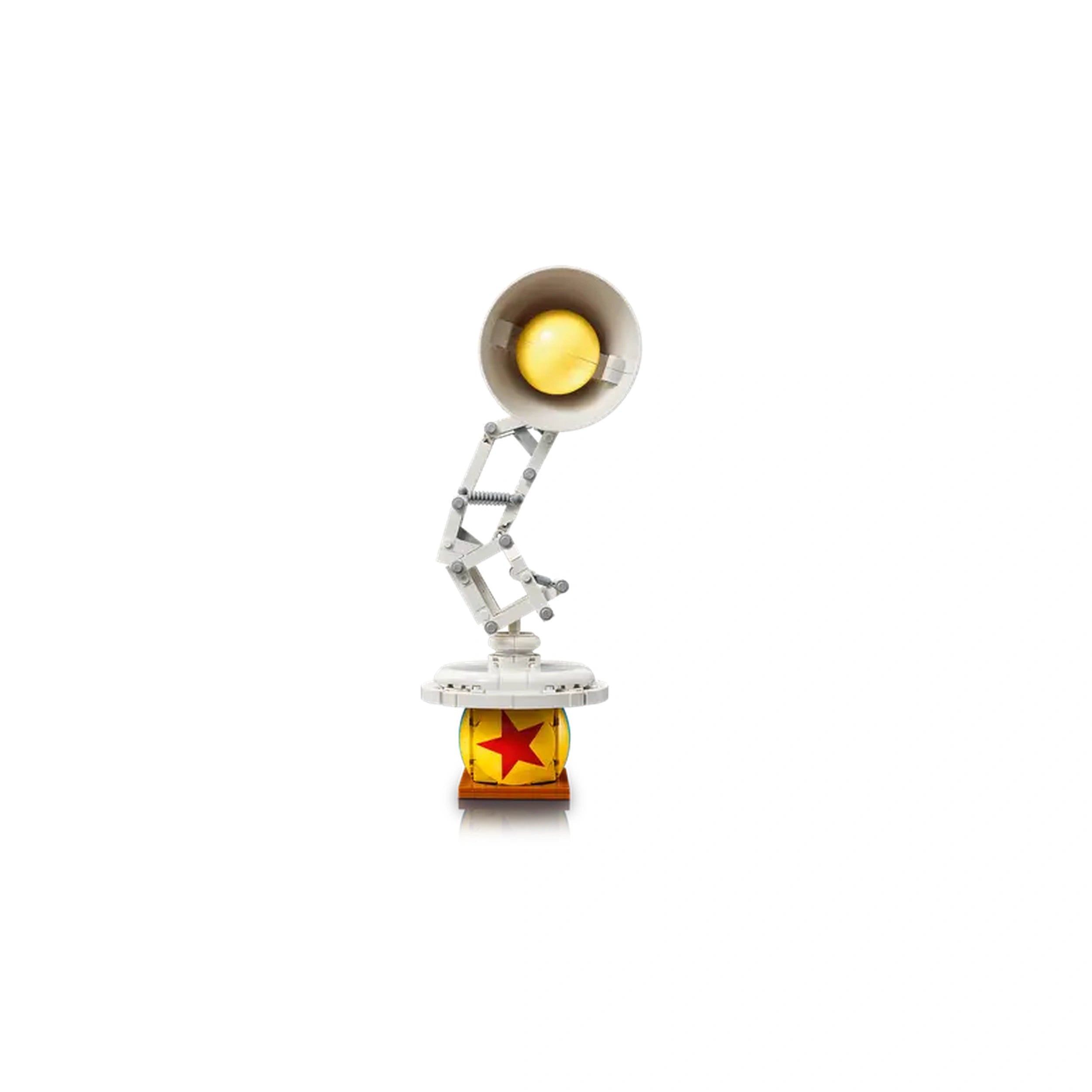 LEGO Disney Pixar Luxo Jr. collectible toy features a white articulated lamp with a yellow bulb, mounted on a round base with a red star design.