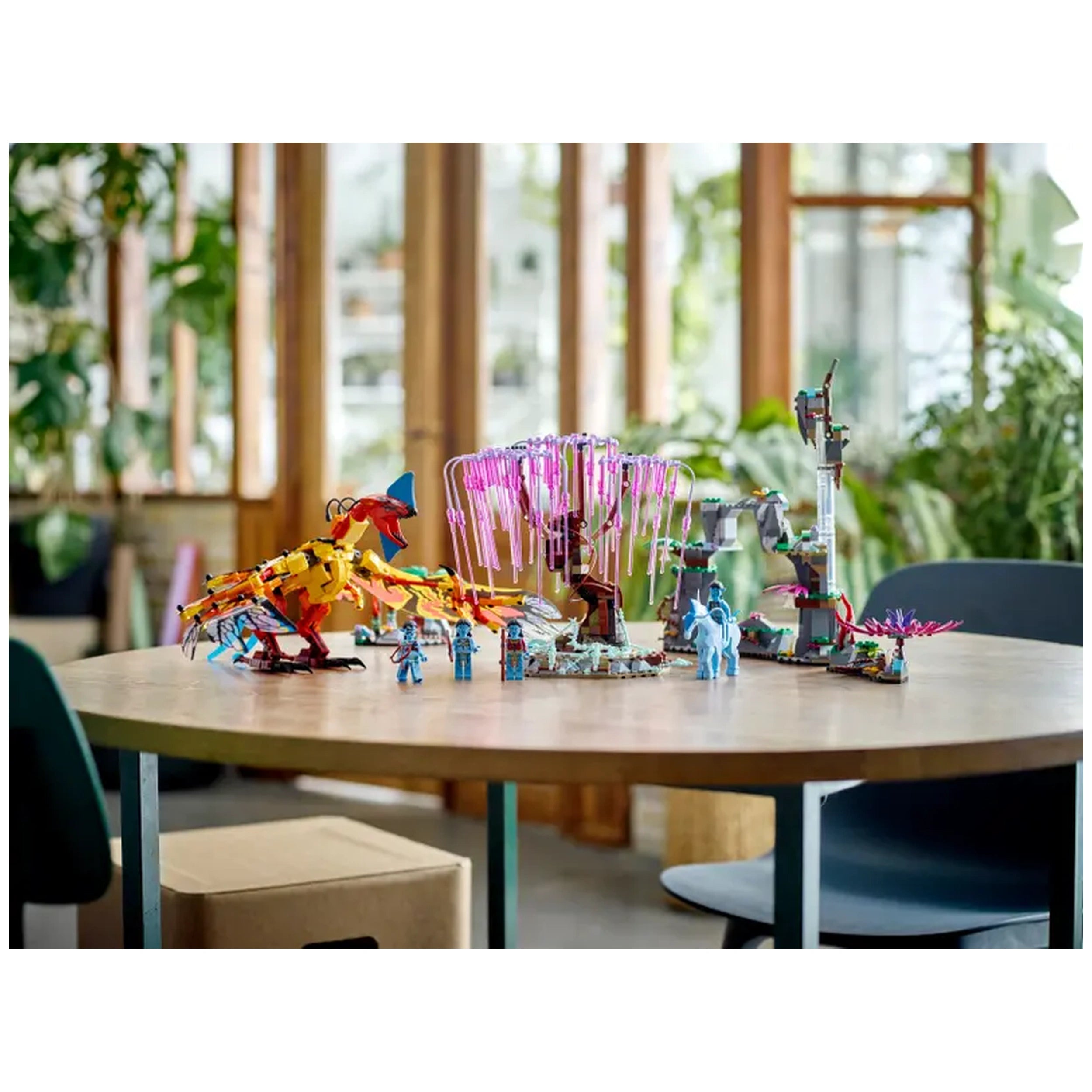 Colorful LEGO® Avatar set featuring a detailed Toruk figure, Tree of Souls with pink tendrils, and four minifigures on a wooden table.