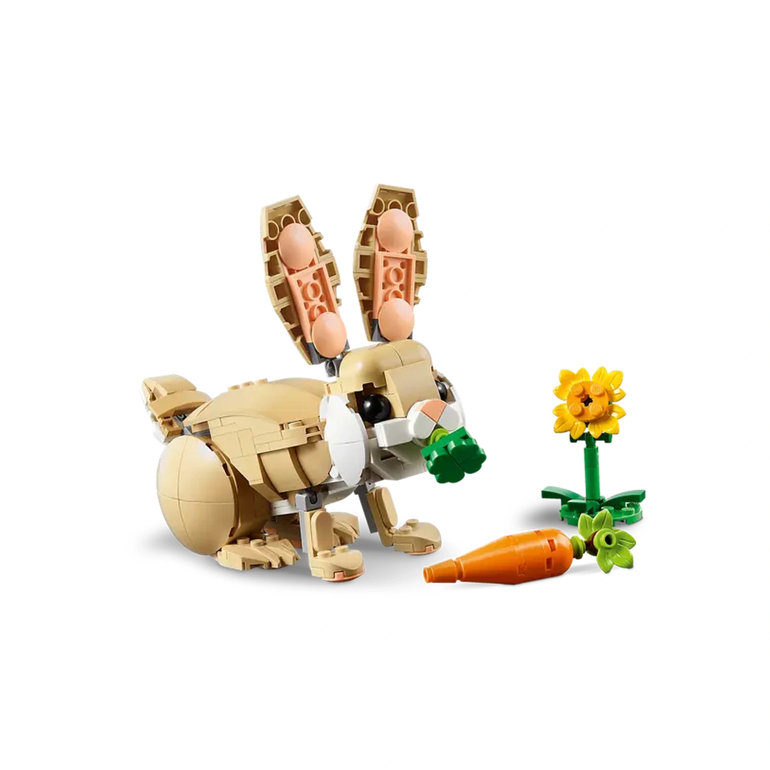 A cute LEGO Creator bunny figure in beige and white, holding a green vegetable in its mouth. Next to it, a bright yellow sunflower and an orange carrot on the ground.