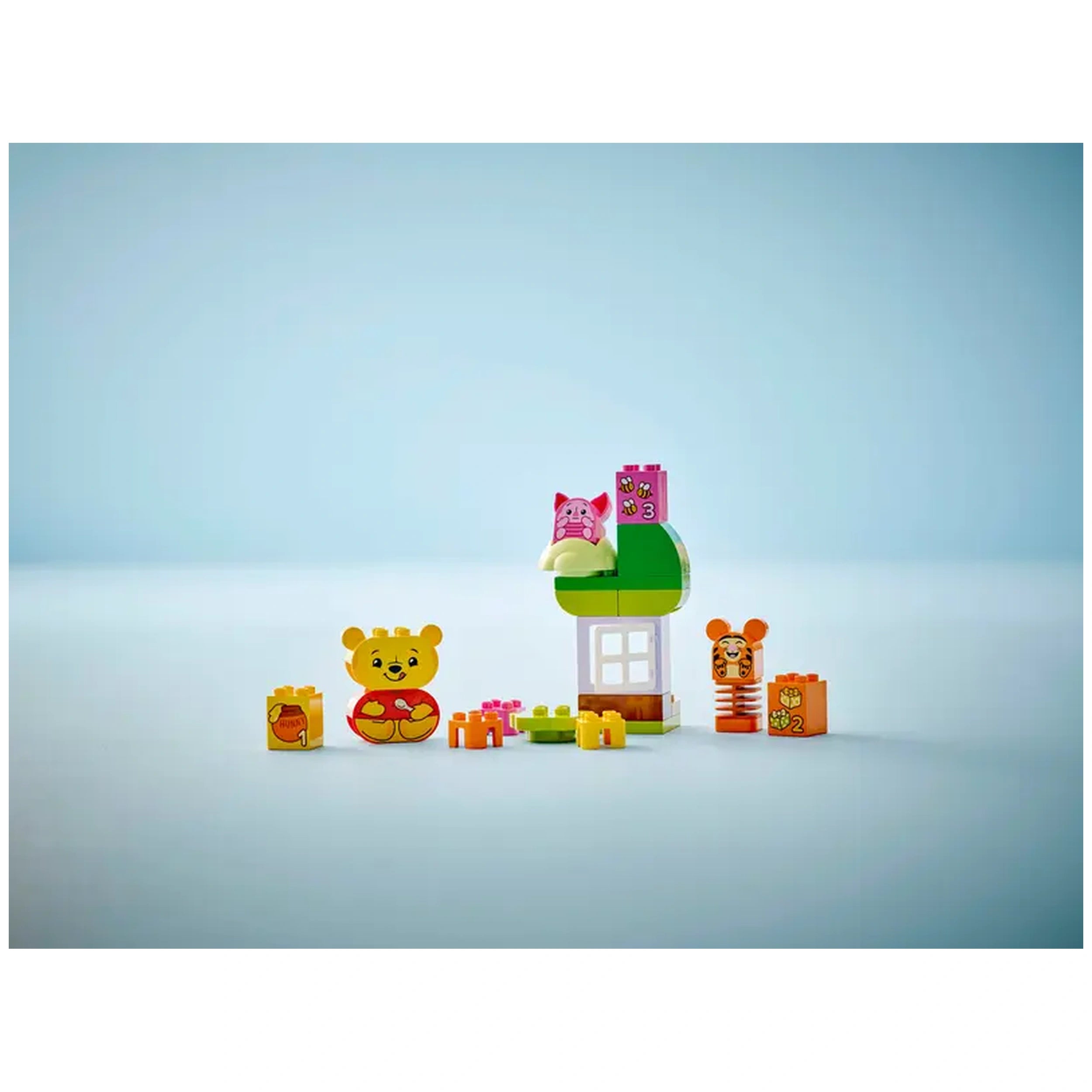 Colorful LEGO® DUPLO® set featuring Winnie the Pooh, Tigger, and Piglet near a birthday-themed house with gift boxes.