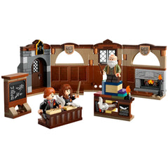 Hogwarts Charms Class LEGO set featuring two students at desks, a teacher with a wand, a chalkboard, and a cozy fireplace, all in intricate detail.