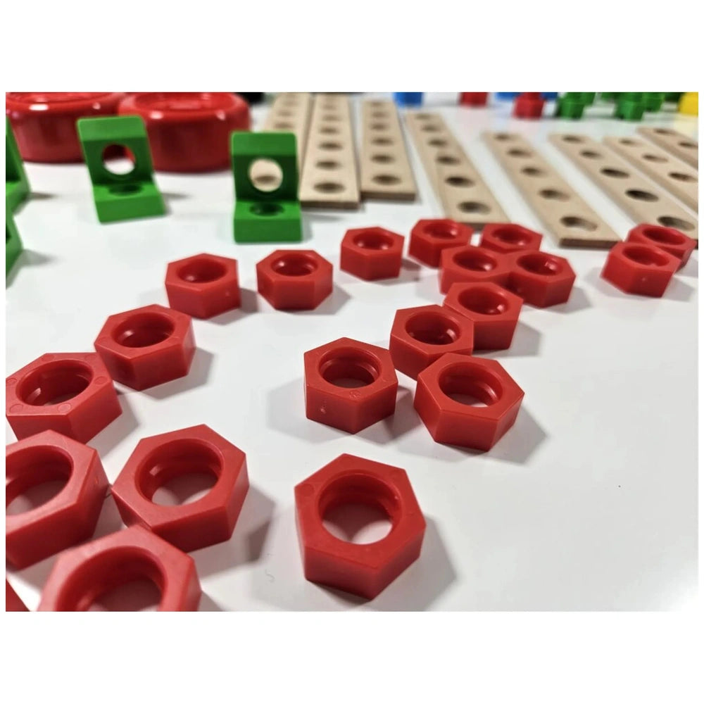 Red plastic hexagonal nuts and green brackets alongside beige wooden planks with holes on a white surface.