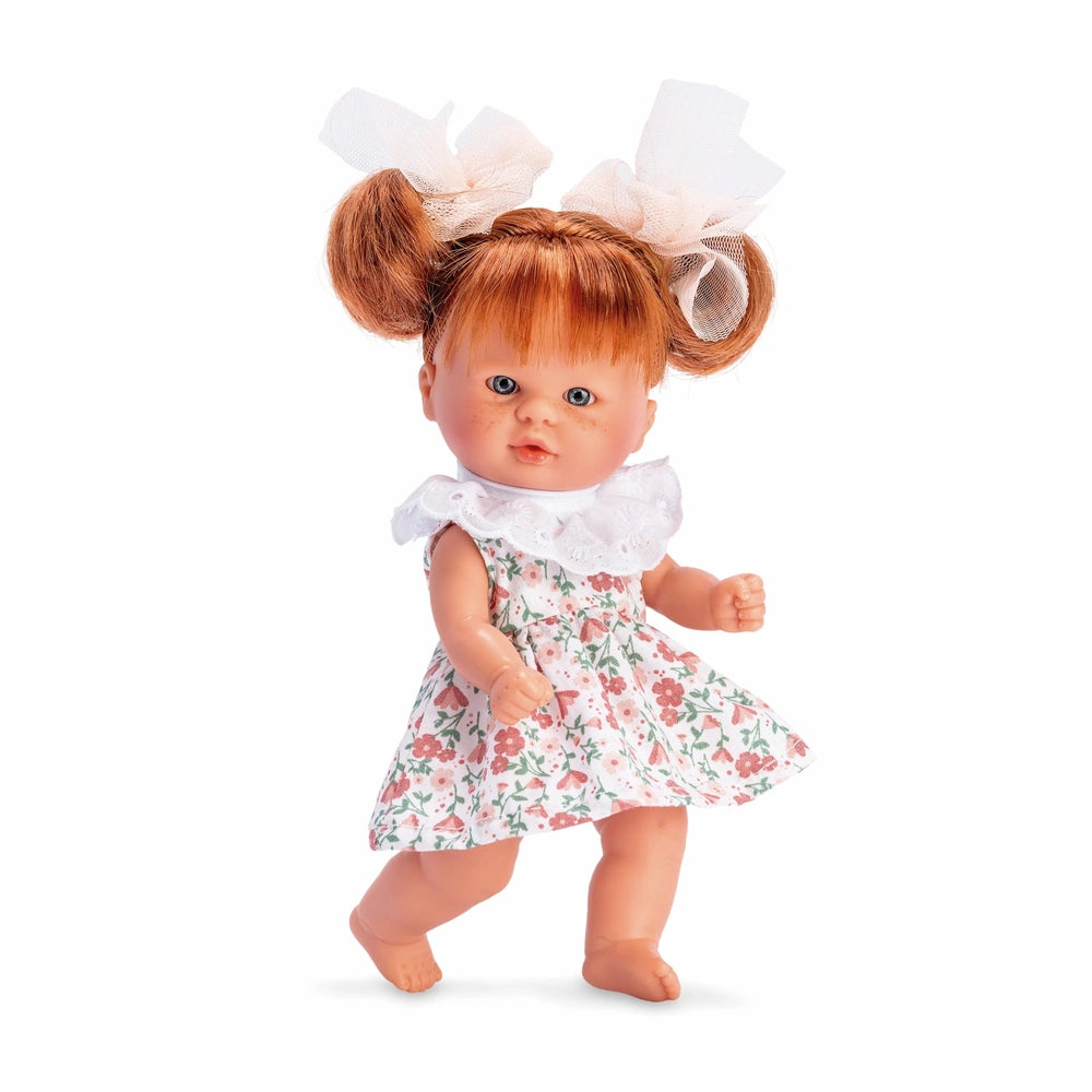 ASI Bomboncín Doll with reddish hair, wearing a salmon floral dress with bows, stands with an articulated pose.