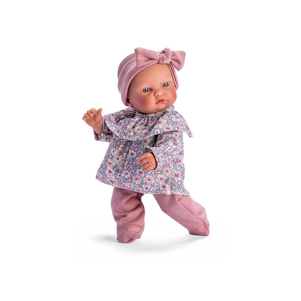 Gordi doll in a floral shirt and pink leggings, adorned with a matching pink headband, showcasing charming light-colored eyes.
