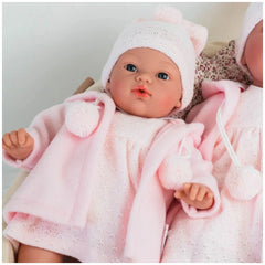 ASI Dolls Koke in pink duffle coat and knit hat, features lifelike blue eyes and delicate facial details.