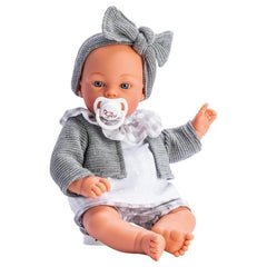 Koke doll by ASI, 36 cm, wears gray jacket and headband, white outfit, and polka-dot pololo, holding a pacifier.