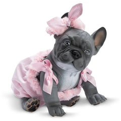 Gray bulldog doll in pink romper with bows sitting on white background, looking forward with tilted head.