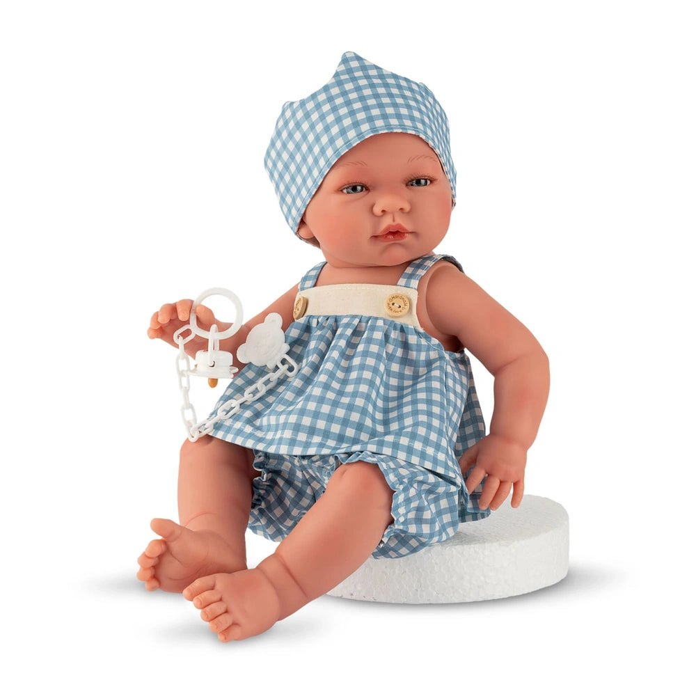 ASI Dolls - Maria Collection Set Noel with Crown features a light-skinned doll in a blue gingham dress and hat, seated on a b