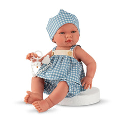 ASI Dolls - Maria Collection Set Noel with Crown features a light-skinned doll in a blue gingham dress and hat, seated on a b