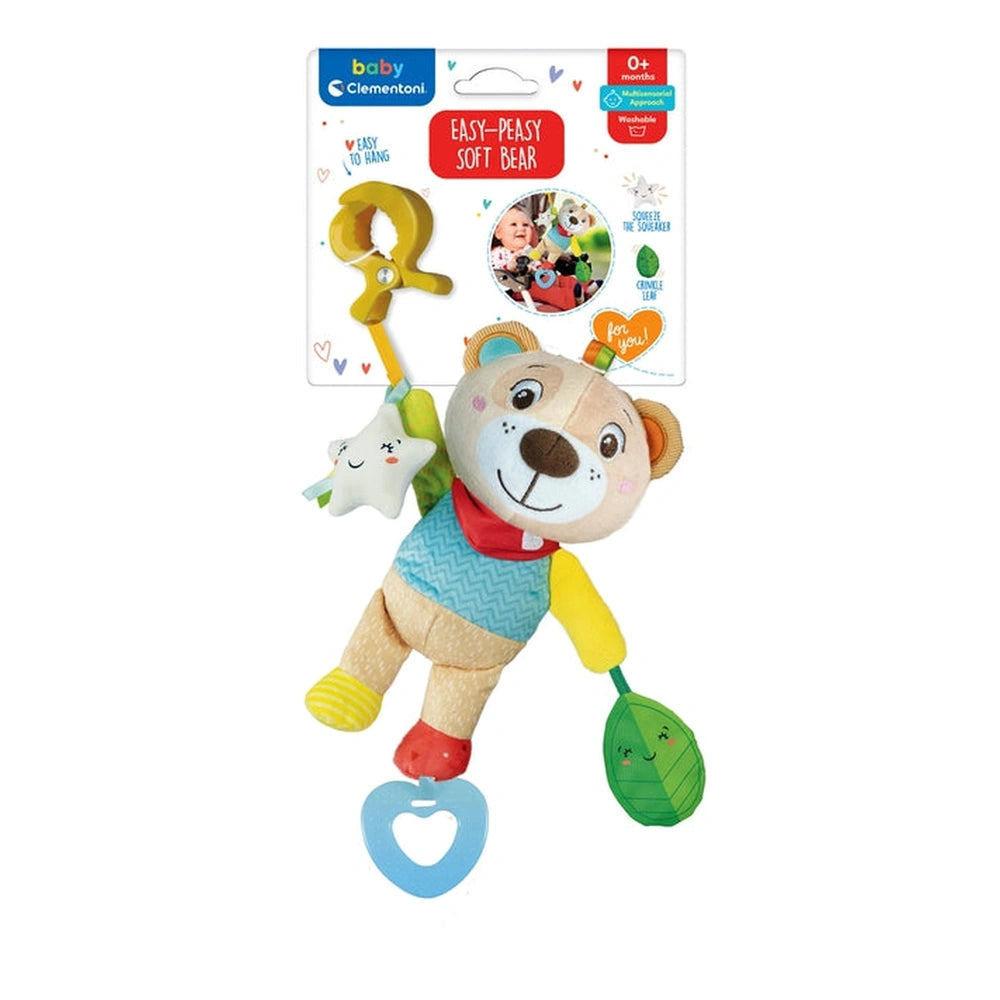 Baby Clementoni Easy-Peasy Soft Bear is a plush toy with a smiling face, holding a rattle and a leaf, hanging on a hook.