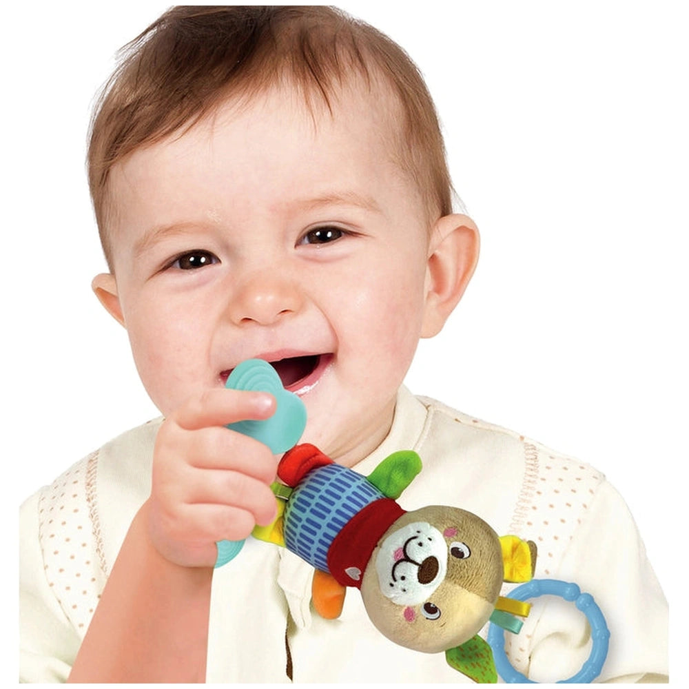 Baby Clementoni Lovely Soft Dog Rattle held by a smiling child in a white top, featuring a red and yellow design with a blue 