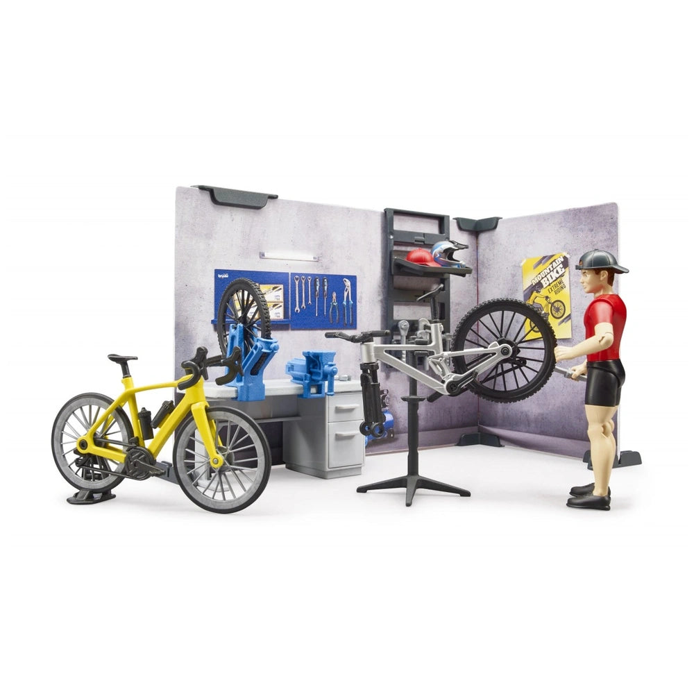 Toy set of a bike shop with a figure repairing a bike, yellow bicycle, tools, and workshop details.