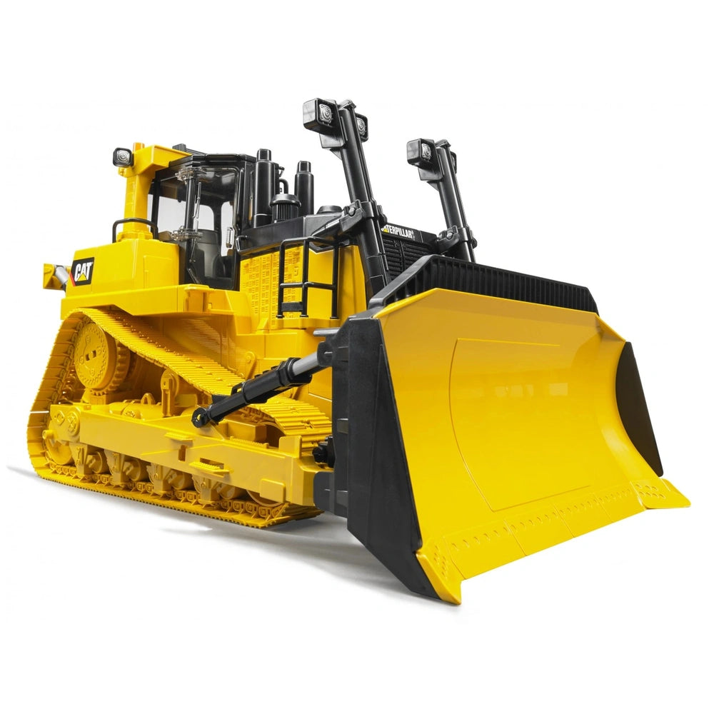 Yellow Bruder CAT large track-type tractor toy with realistic details, front blade, and rubber tracks, viewed from a low angle.